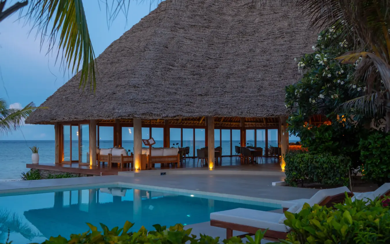Beachfront dining pavilion with thatched roof overlooking ocean at dusk, Ocean Boutique Hotel, Zanzibar & Pemba, Tanzania