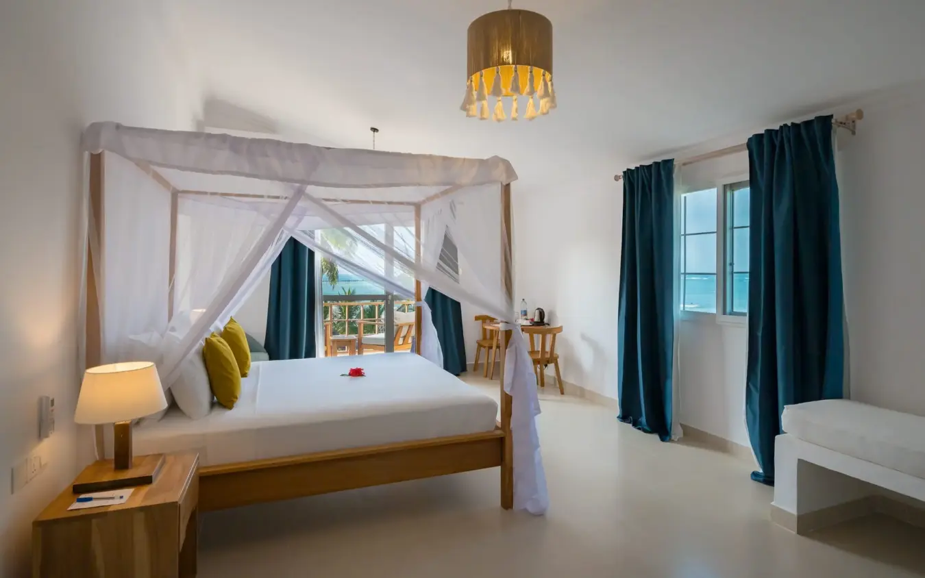 Luxury bedroom suite with four-poster bed and ocean view through glass doors, Ocean Boutique Hotel, Zanzibar & Pemba, Tanzania
