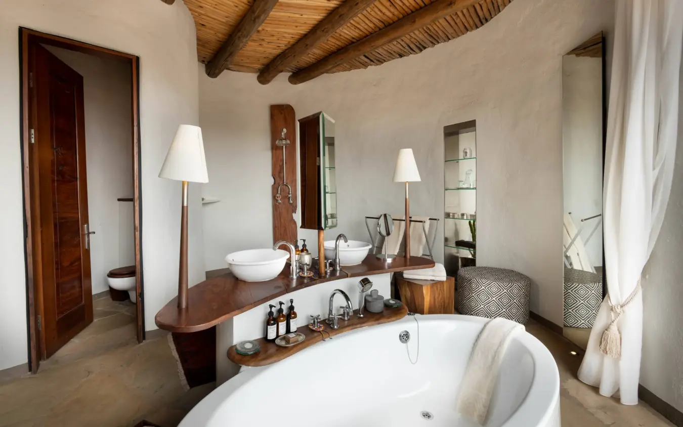 Luxury bathroom with freestanding tub and double vanity with wooden beams, Ol Donyo Lodge, Amboseli and Chyulu Hills, Kenya