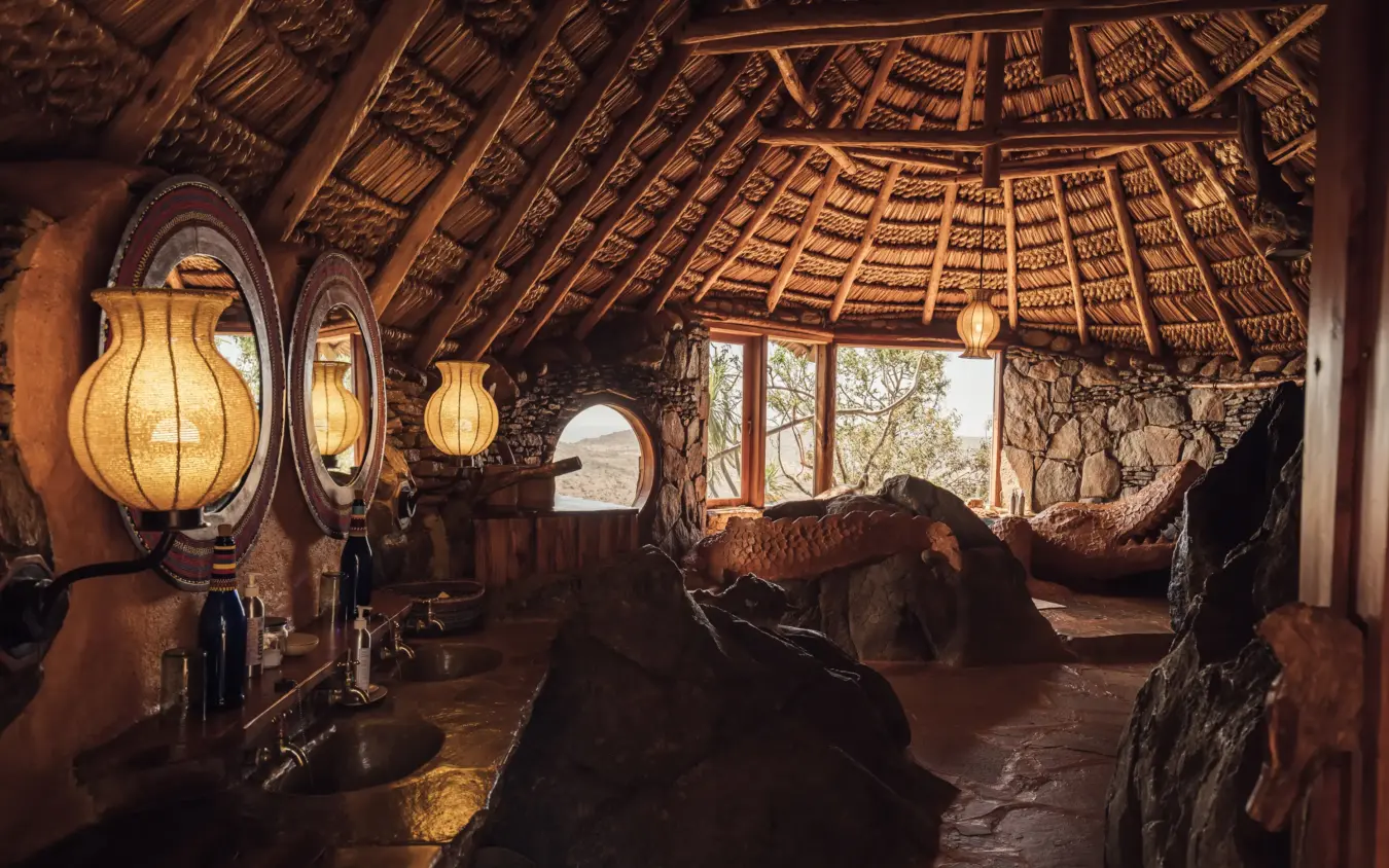 Rustic lodge interior with lanterns, wooden beams and savanna views through windows, Ol Malo House, Laikipia Highlands, Kenya