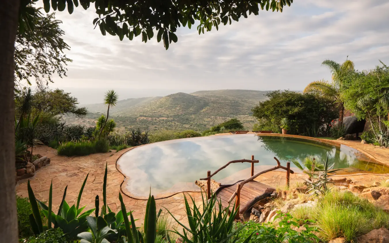 Infinity pool overlooking mountainous valley landscape at midday, Ol Malo House, Laikipia Highlands, Kenya