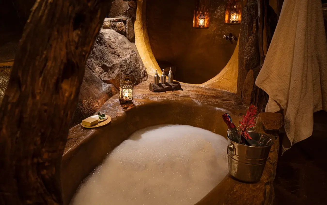 Natural stone bathroom with sunken bath carved into rock formations, Ol Malo Lodge, Laikipia Highlands, Kenya