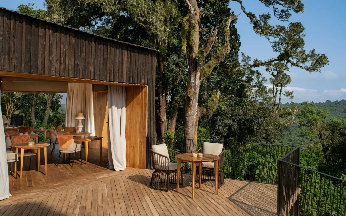Modern wooden lodge with deck overlooking forested valley landscape, Osonjoi Lodge, Ngorongoro Crater, Tanzania