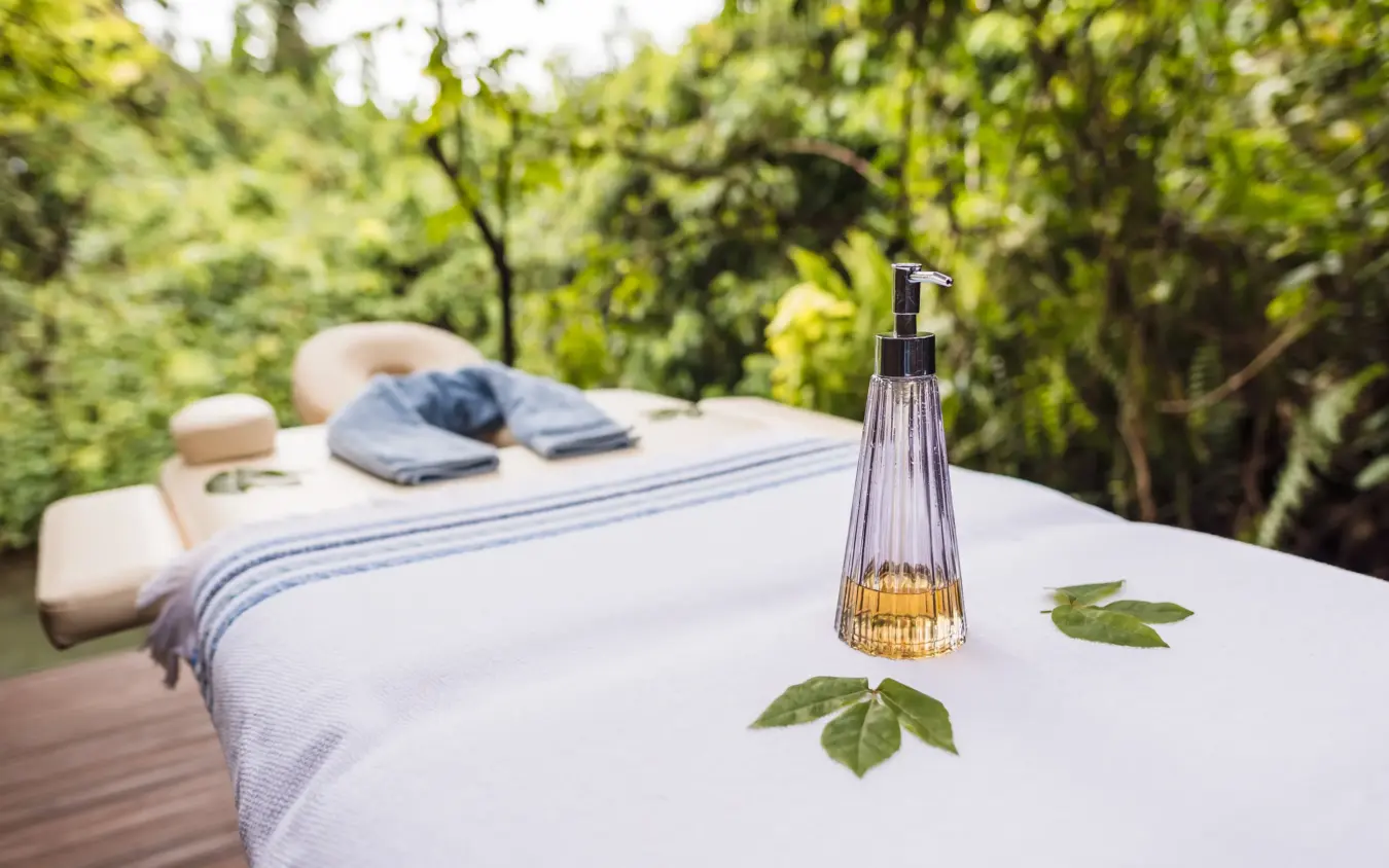 Outdoor massage table with oils and towels overlooking garden trees, Osonjoi Lodge, Ngorongoro Crater, Tanzania