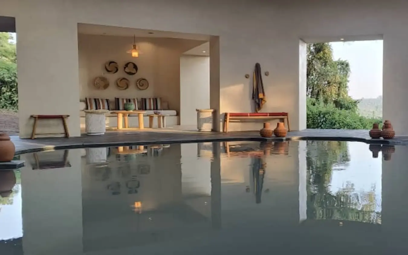 Infinity pool with mountain views reflecting modern lodge interior, Osonjoi Lodge, Ngorongoro Crater, Tanzania