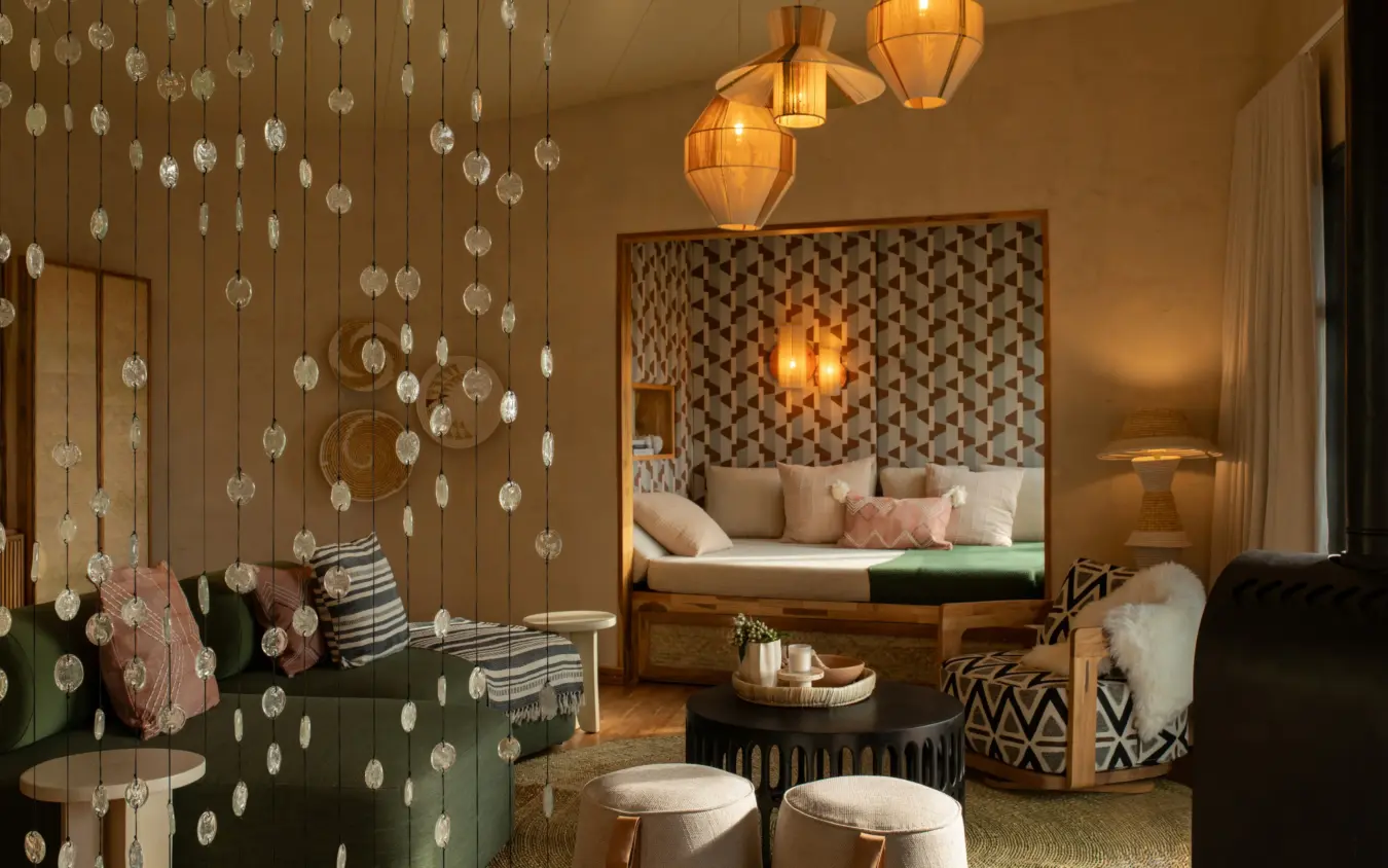 Luxurious bedroom suite with beaded curtain partition and ambient lighting, Osonjoi Lodge, Ngorongoro Crater, Tanzania