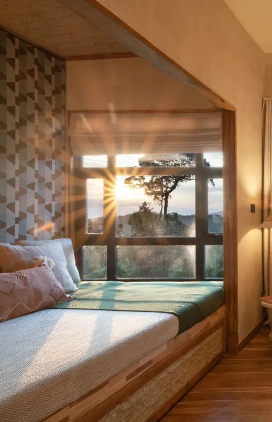 Bedroom window nook overlooking forested hills at golden hour, Osonjoi Lodge, Ngorongoro Crater, Tanzania
