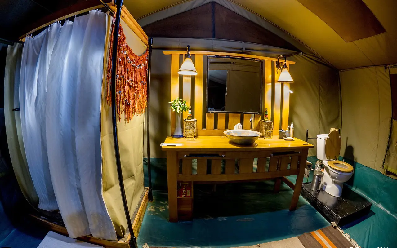 Luxury safari glamping tent bathroom with yellow vanity and mirror, Porini Lion Camp, Maasai Mara, Kenya