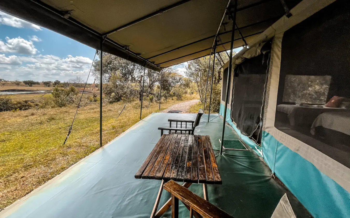 Safari camp deck with dining table overlooking wetland landscape, Porini Rhino Camp, Laikipia Highlands, Kenya