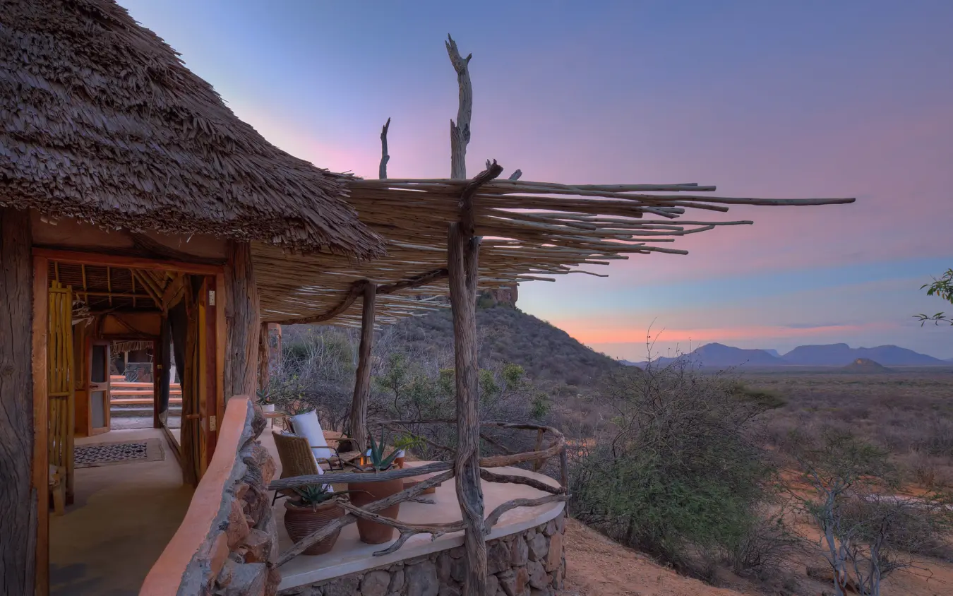 Thatched lodge veranda with wooden pergola overlooking savanna landscape at dusk, Reteti House, Northern Kenya, Kenya
