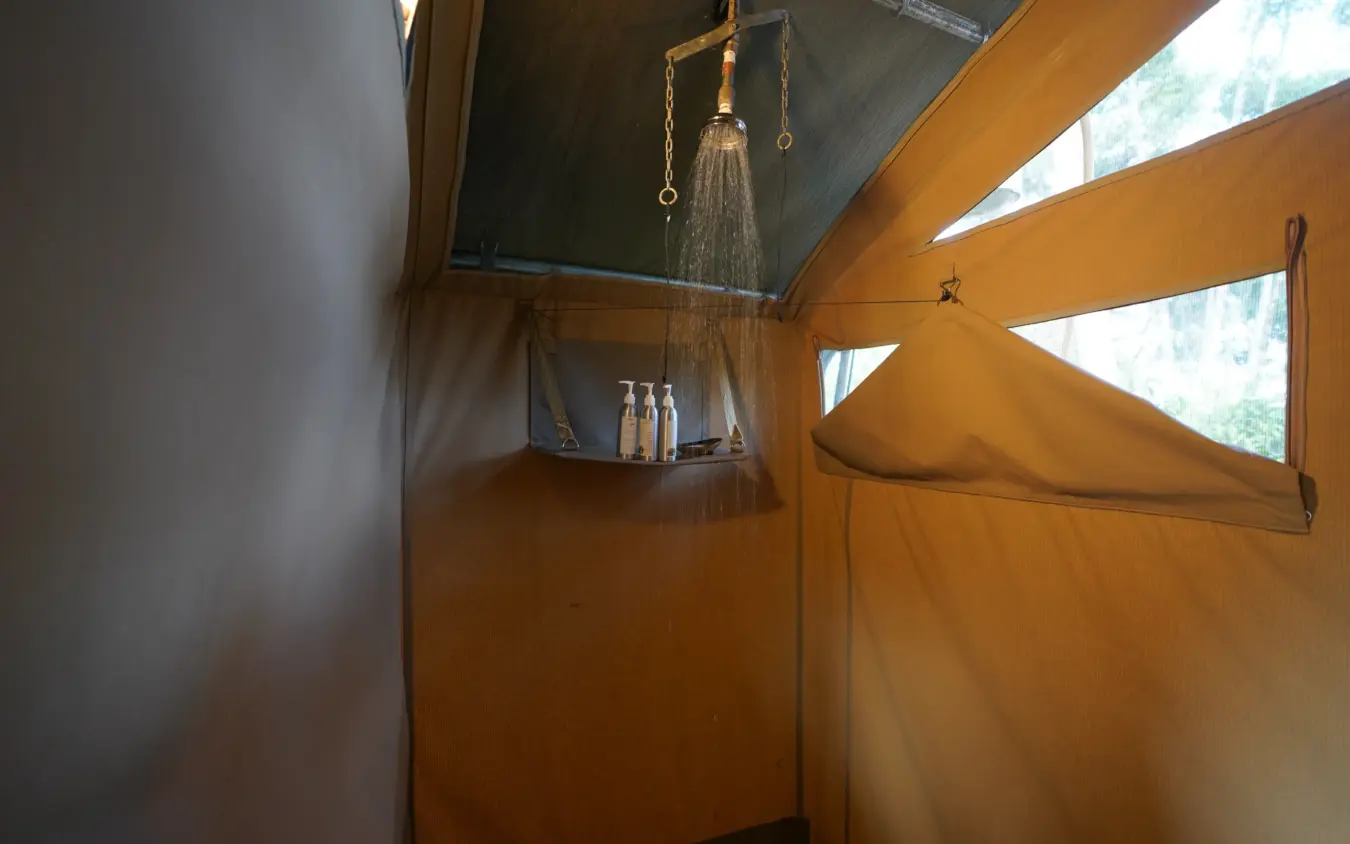 Outdoor shower enclosure with canvas walls and skylight views, Roca River Camp, Maasai Mara, Kenya