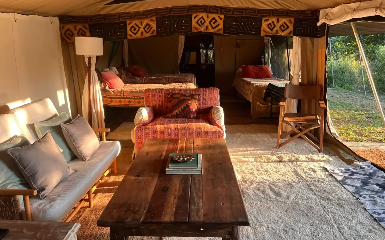 Luxury safari tent interior with beds and wooden furnishings at sunset, Roca River Camp, Maasai Mara, Kenya