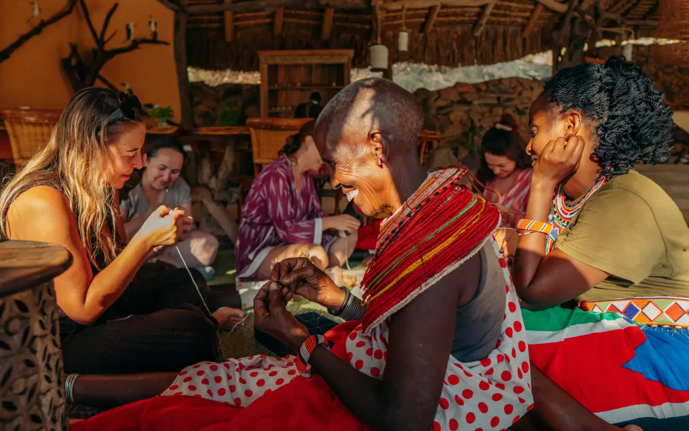 Cultural interaction with local community members inside traditional dwelling, Sarara Camp, Northern Kenya, Kenya