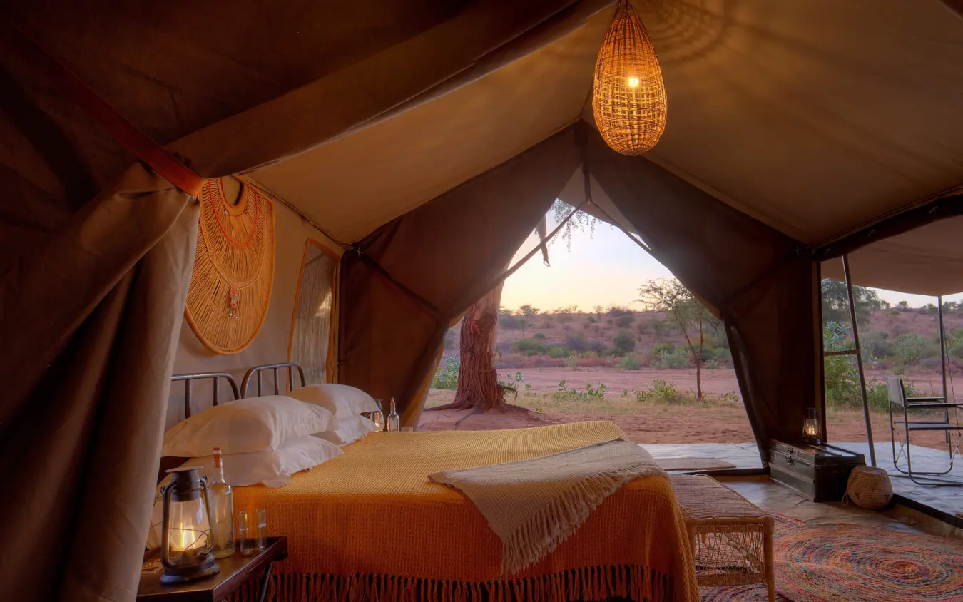 Luxury safari tent bedroom with open view of savanna landscape at dusk, Sarara Wilderness, Northern Kenya, Kenya