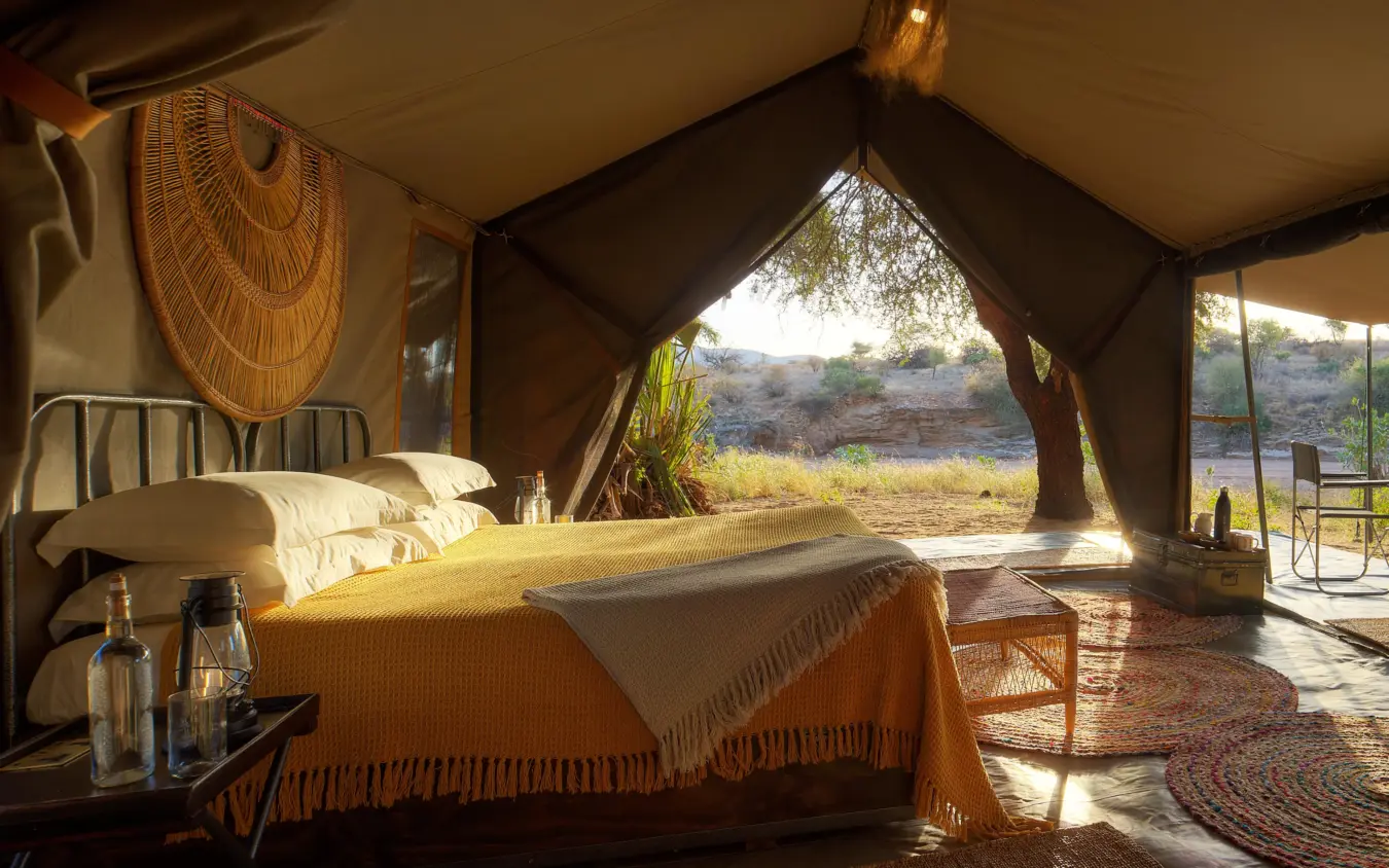 Luxury safari tent interior with bed overlooking river valley landscape, Sarara Wilderness, Northern Kenya, Kenya