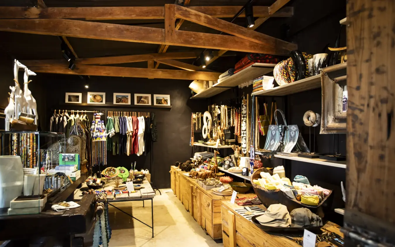 Retail boutique interior with wooden beams and clothing displays, Segera, Laikipia Highlands, Kenya