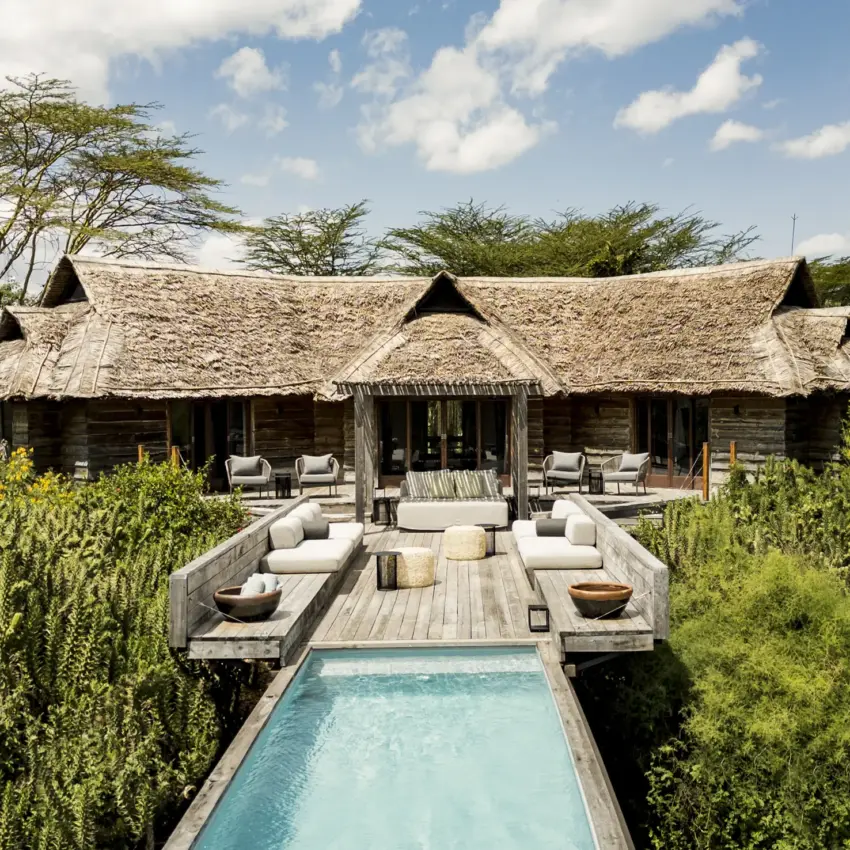 Luxury lodge with thatched roof structures and infinity pool in savanna setting, Segera, Laikipia Highlands, Kenya