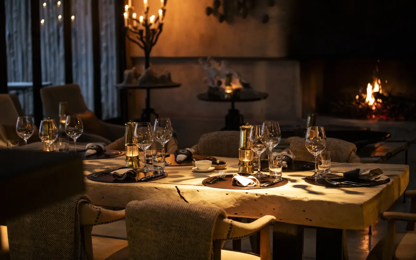 Fine dining table set for dinner with fireplace and night ambiance, Segera, Laikipia Highlands, Kenya