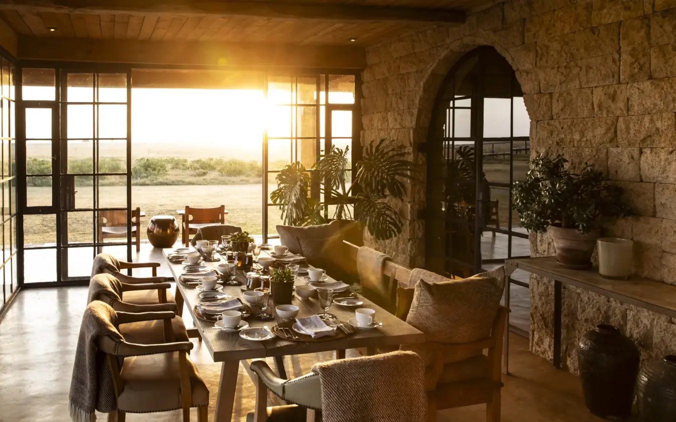 Dining room with river view at sunset through large windows, Segera, Laikipia Highlands, Kenya