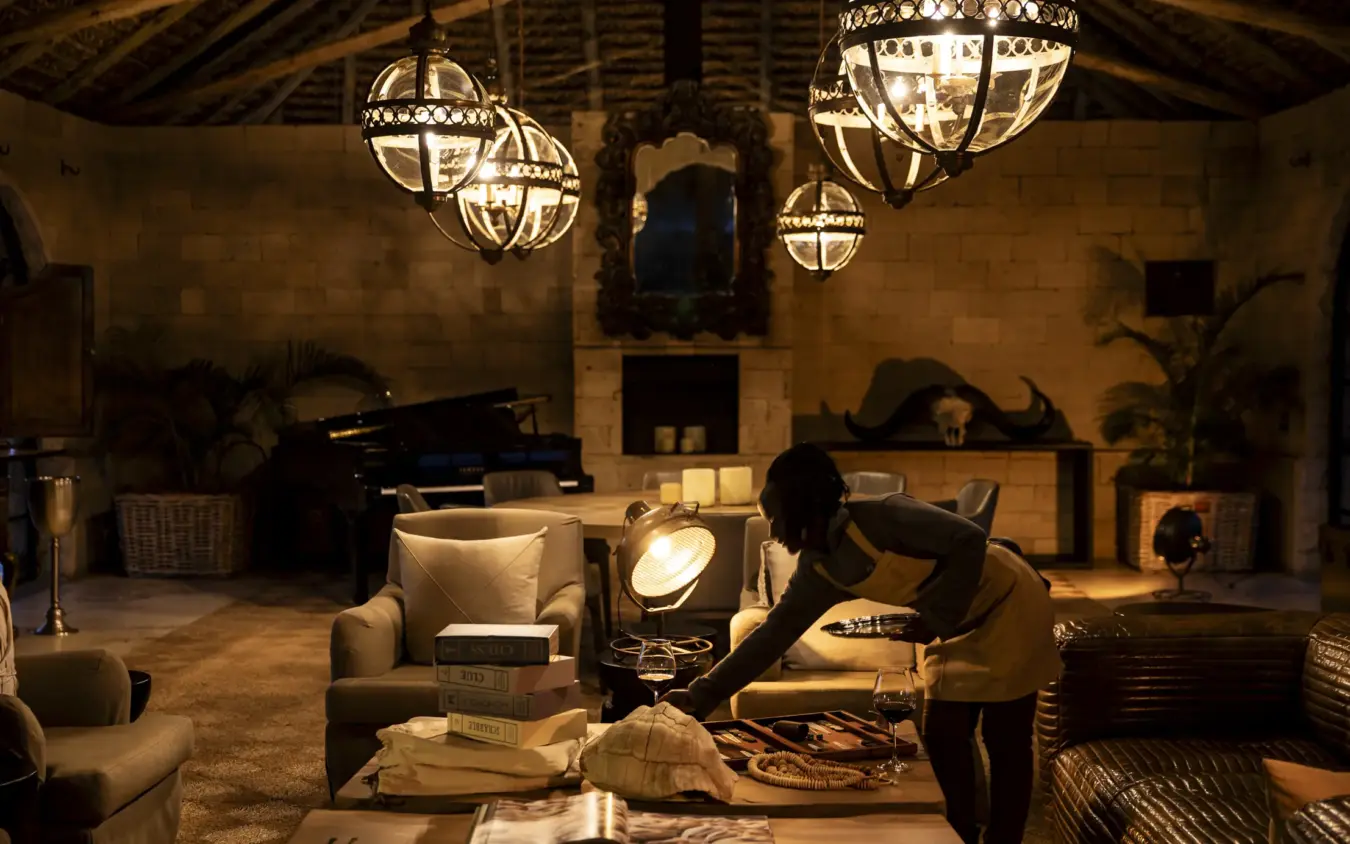 Luxury lounge interior with decorative lighting and stone architecture at night, Segera, Laikipia Highlands, Kenya