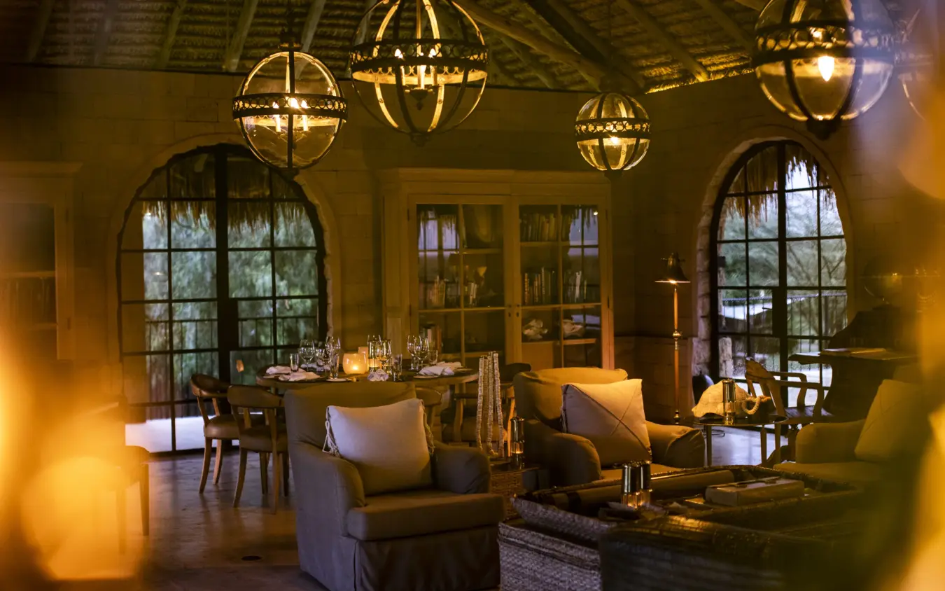 Luxury lodge interior with spherical chandeliers and arched windows at dusk, Segera, Laikipia Highlands, Kenya
