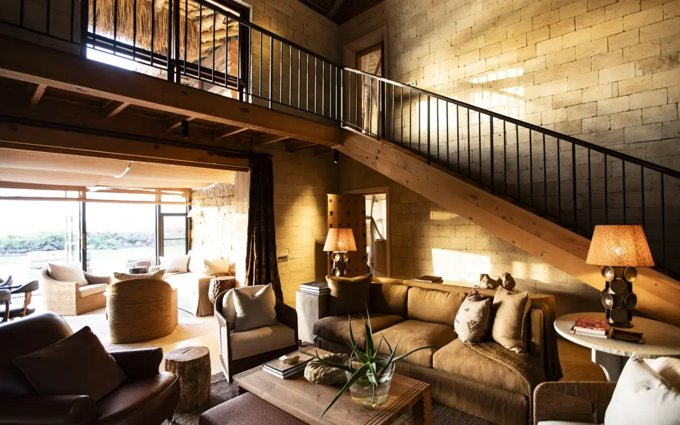 Interior lounge with mezzanine level and expansive windows overlooking landscape, Segera, Laikipia Highlands, Kenya