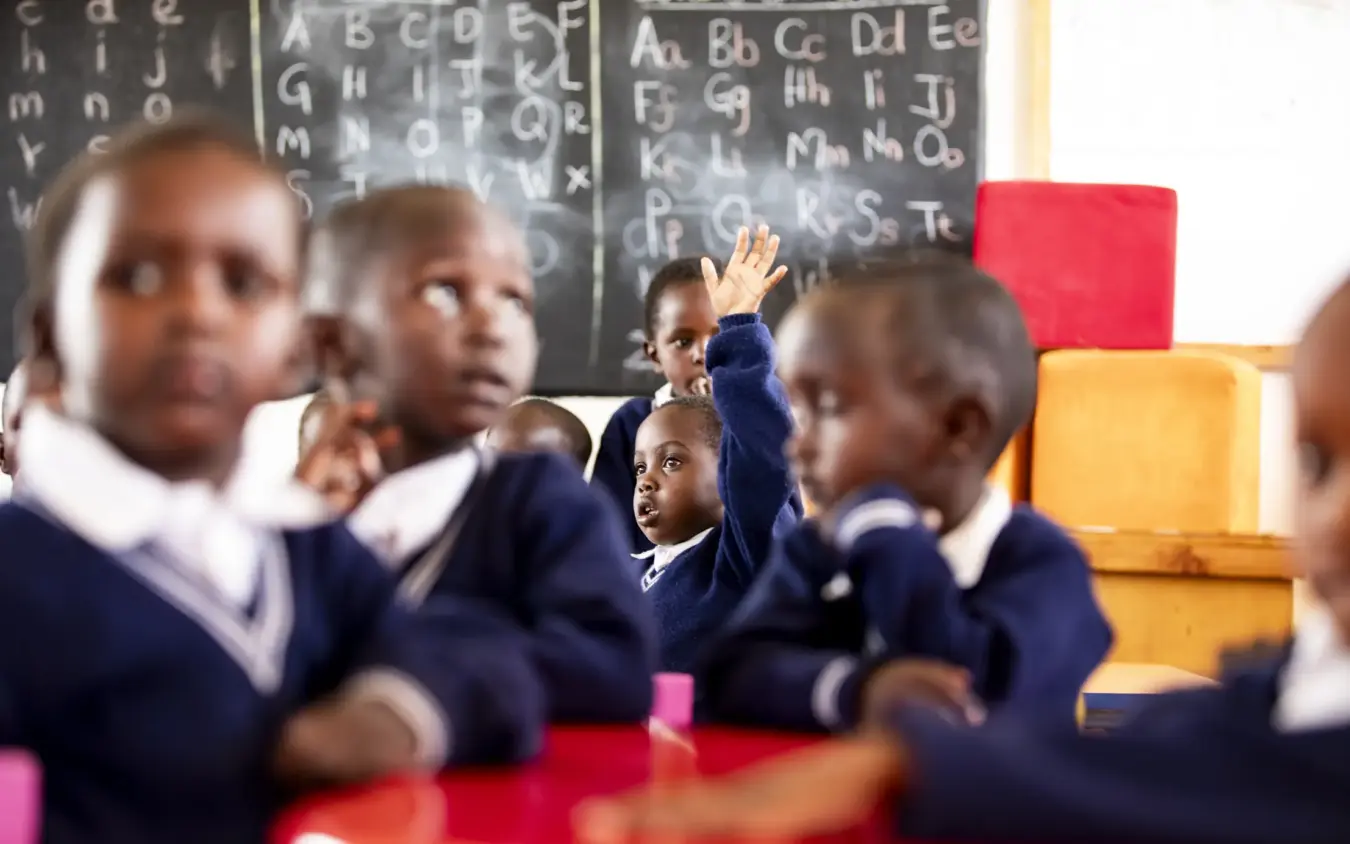 Classroom with students at desks and alphabet chart on blackboard, Segera, Laikipia Highlands, Kenya