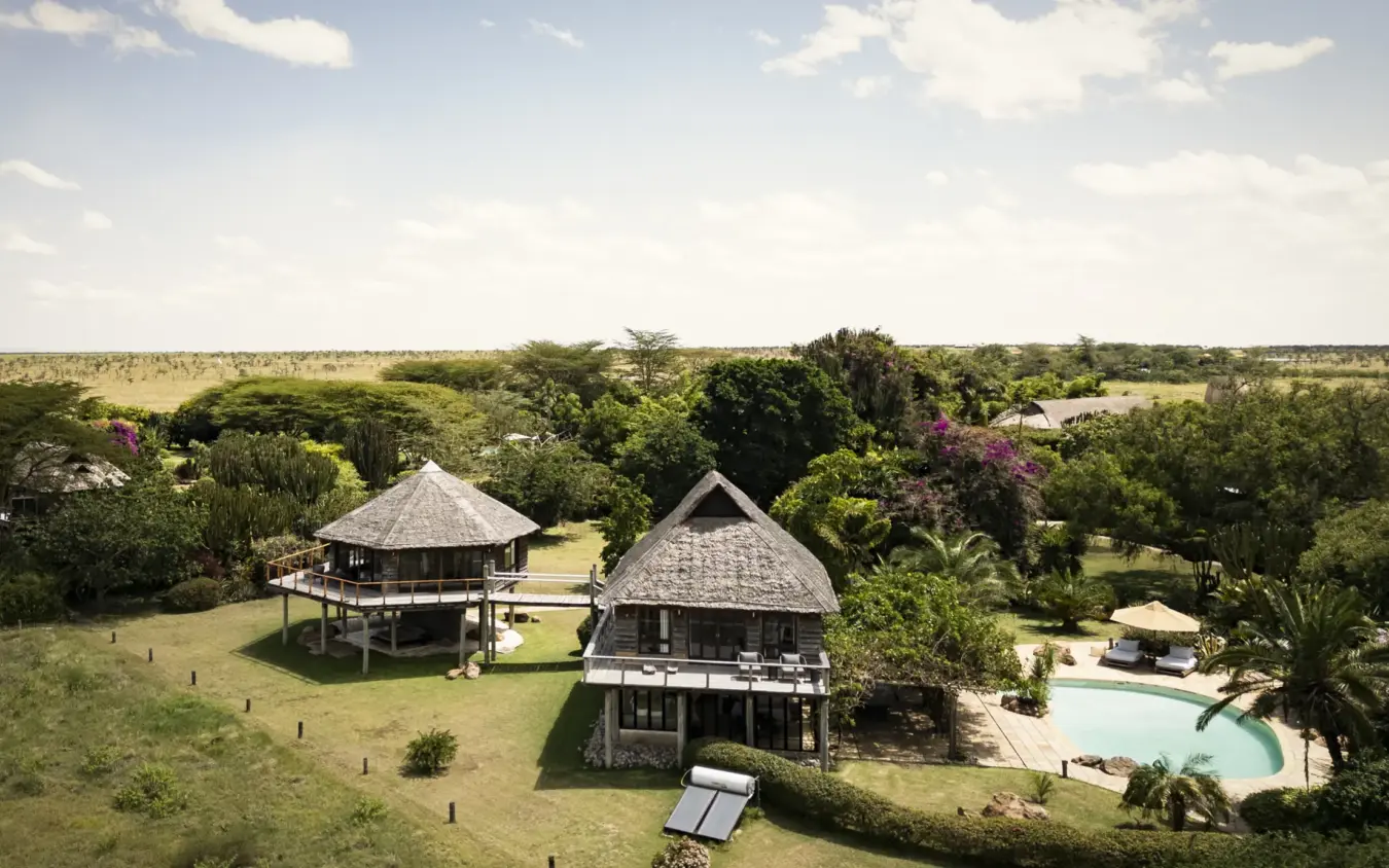 Aerial view of safari lodge with thatched-roof buildings and pool overlooking savanna, Segera, Laikipia Highlands, Kenya