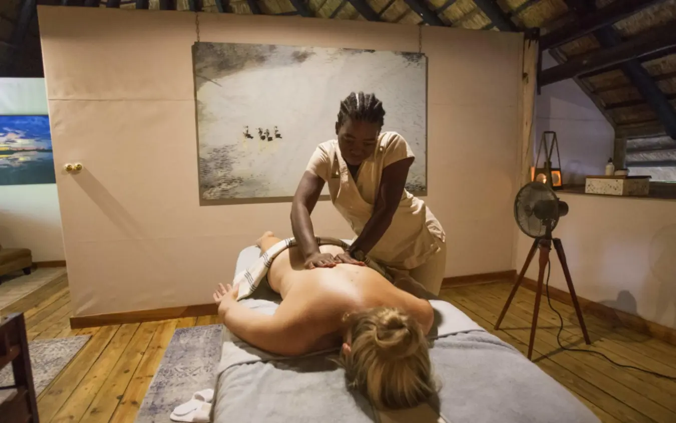 Spa therapist performing massage treatment on guest, Selinda Camp, Selinda Reserve, Botswana