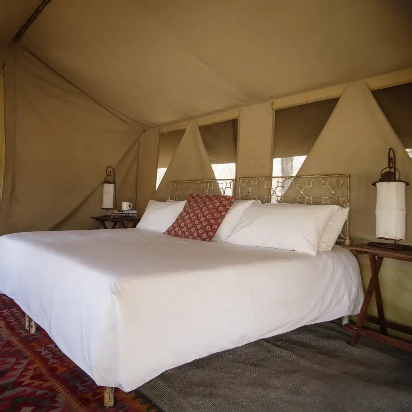 Glamping tent bedroom with canopy bed and canvas walls, Serian Serengeti Mobile Kusini, Serengeti National Park, Tanzania