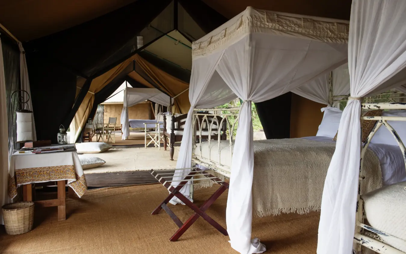 Safari tent interior with draped canopy beds and seating area, Serian “The Original”, Maasai Mara, Kenya