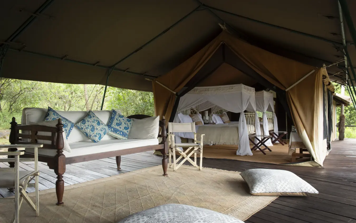 Safari tent interior with canopied bed and seating area, Serian “The Original”, Maasai Mara, Kenya