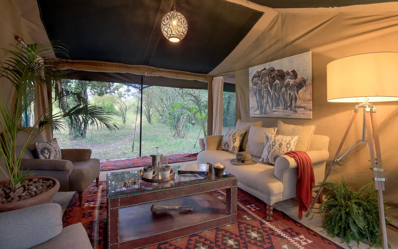 Luxury safari lodge interior with wildlife artwork and savanna views through floor-to-ceiling windows, Seringet Mara Camp, Maasai Mara, Kenya