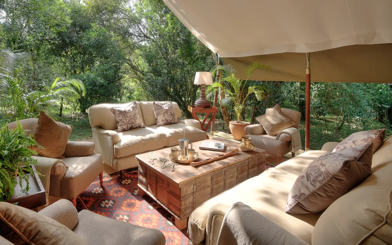 Shaded outdoor lounge area with comfortable seating beneath canvas awning, Seringet Mara Camp, Maasai Mara, Kenya