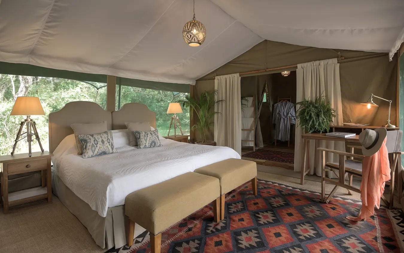 Luxury safari tent bedroom with glazed walls overlooking woodland, Seringet Mara Camp, Maasai Mara, Kenya
