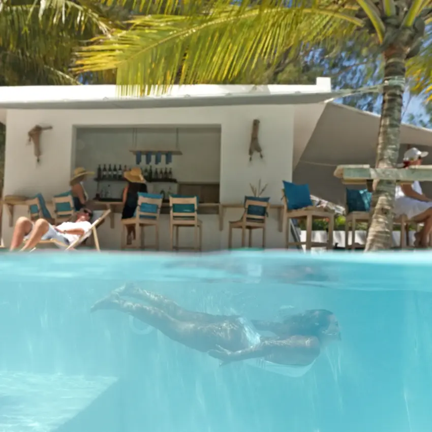 Swimming pool with guest lounging underwater near beachfront bar, Sharazad Boutique Hotel, Zanzibar & Pemba, Tanzania