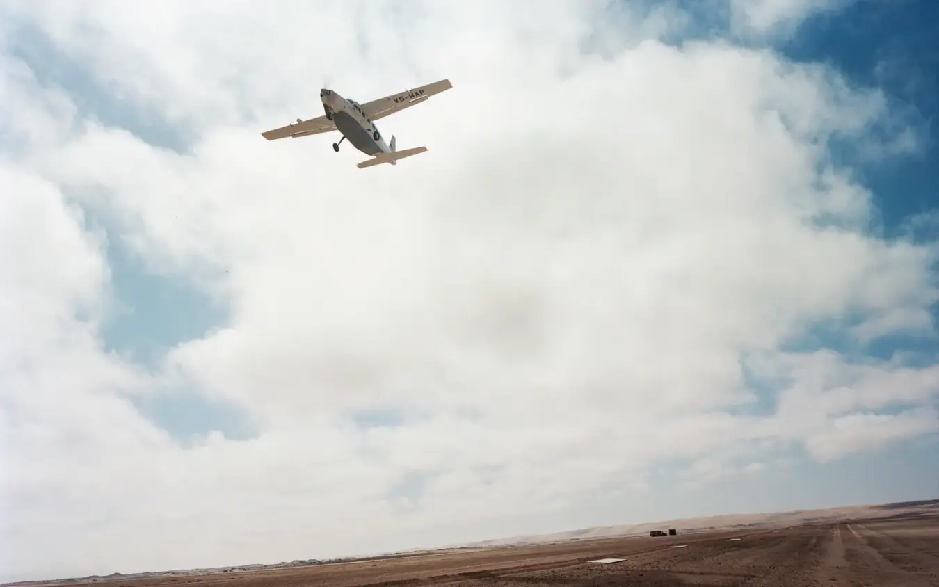 Small aircraft landing on remote desert airstrip, Shipwreck Lodge, Skeleton Coast, Namibia