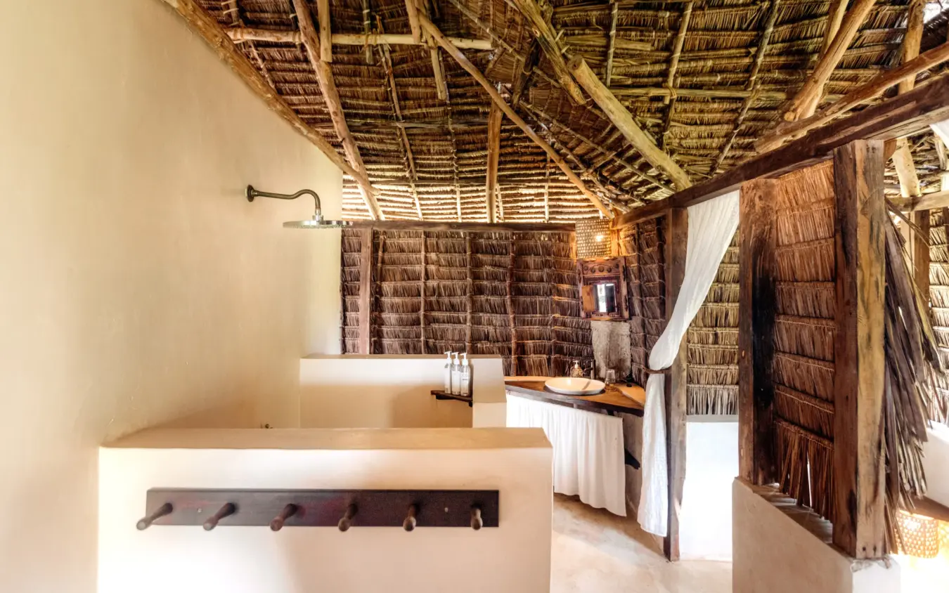 Rustic bathroom interior with thatched roof and wooden walls, The Cabanas, Lamu Archipelago, Kenya