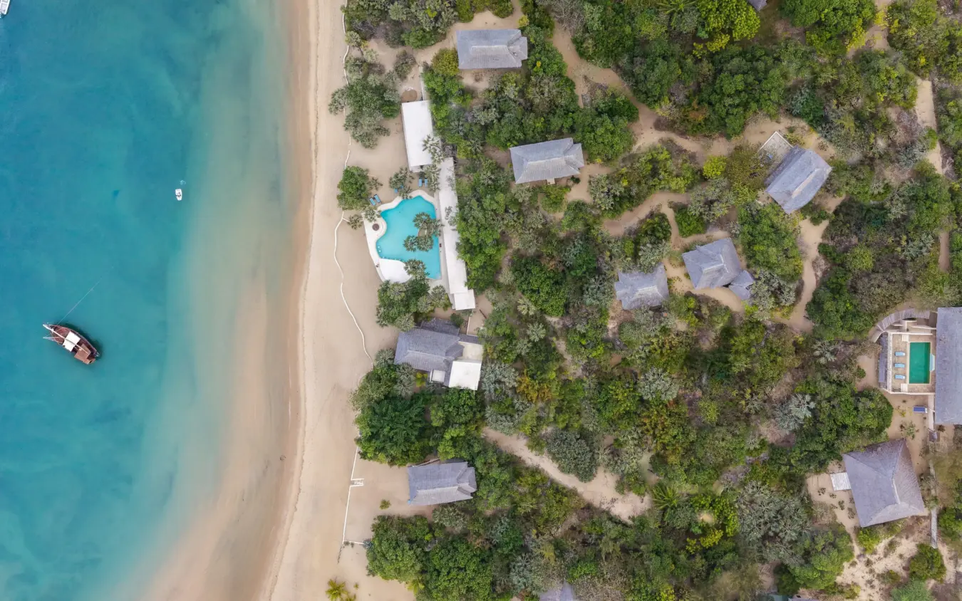 Beachfront resort with pool nestled among tropical trees and turquoise waters, The Cabanas, Lamu Archipelago, Kenya